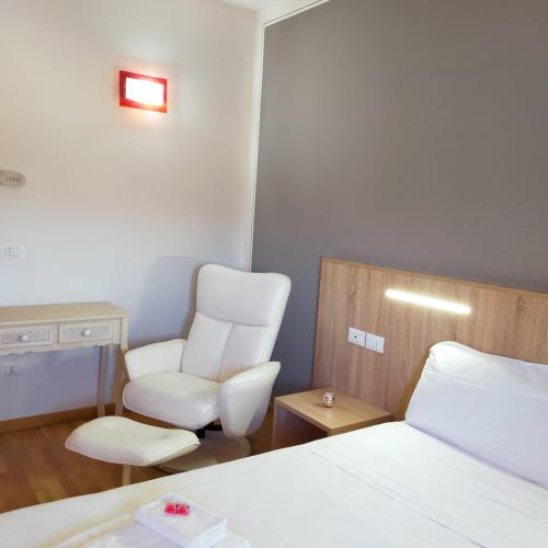 a hotel room with a bed and a chair at Al Cavaliere in Pordenone