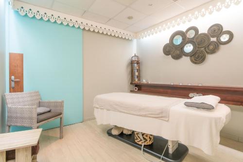 a bedroom with a bed and a chair and a mirror at Village Pierre & Vacances Sainte Anne in Sainte-Anne