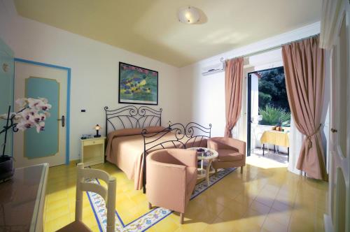 a bedroom with a bed and a table and chairs at Hotel Villa Bianca in Ischia