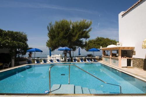 イスキアにあるHotel Villa Biancaのホテル内のスイミングプール(ブルーパラソル付)
