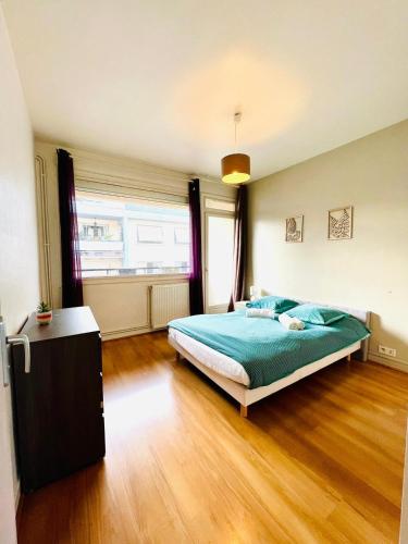 une chambre avec un lit et un parquet dans l'établissement Le Voltaire -2 chambres- 70m2- HYPERCENTRE-Parking-WIFI FIBRE- Nouvelle literie, à Tarbes