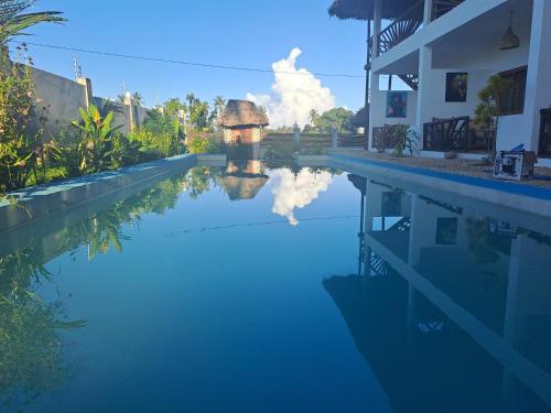 a swimming pool with a reflection in the water at Villa Adelina Zanzibar in Zanzibar City