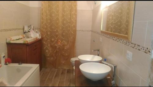 a bathroom with two sinks and a toilet and a shower at Casa scopelliti in Calasetta