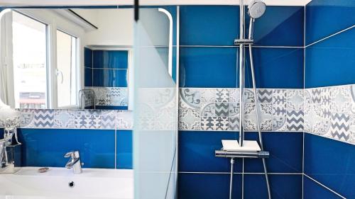 une salle de bain bleue avec une douche et un lavabo dans l'établissement Appartement proche Croisette & Carlton By Palmazur, à Cannes