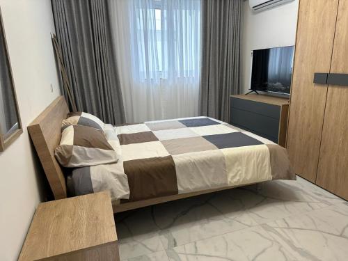 a hotel room with a bed and a television at Skylark 2 Apartment with Terrace in Is-Swieqi