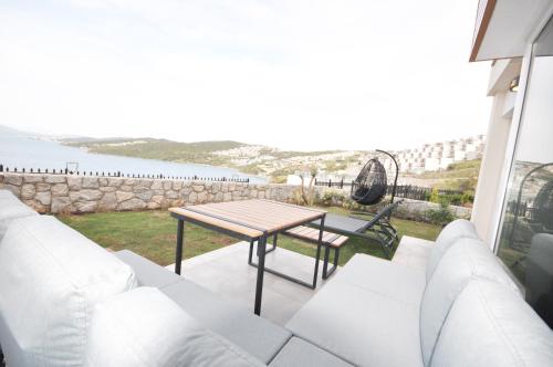 a table and chairs on a balcony with a view of the water at Villa Esteban Özel Plajlı in Bogazici
