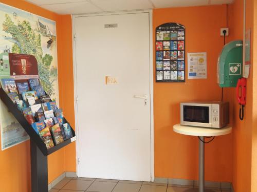 a room with a white door and a microwave at Premiere Classe Saumur in Saumur