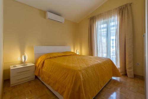 a bedroom with a bed with a yellow bedspread and a window at Villa Bali in Kaštelir