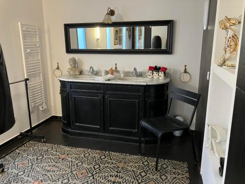 a bathroom with a sink and a chair and a mirror at Maison "LA ROSALINDA-2B" Ghisonaccia in Ghisonaccia