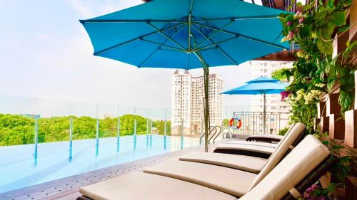 a row of chairs with umbrellas next to a swimming pool at Orchard Garden -Near TSN Airport 5 minutes -Nice in Ho Chi Minh City