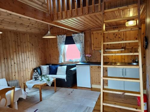 ein Wohnzimmer mit einem Sofa und einem Hochbett in der Unterkunft Älgbergets Bed & Breakfast in Ucklum