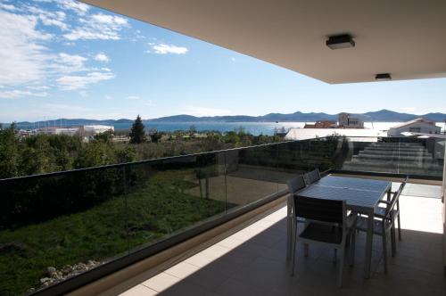 a balcony with a table and chairs and a view at Nikola Luxury Apartments Borik in Zadar
