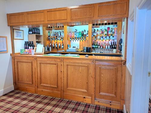 a bar in a room with wooden cabinets at Richmond Hotel in Aberystwyth