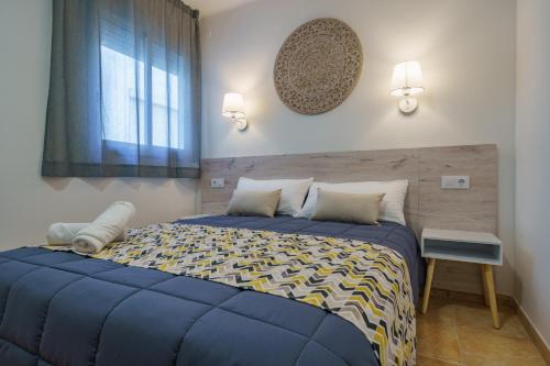 a bedroom with a blue bed and a window at AR Apartaments Camps in Blanes