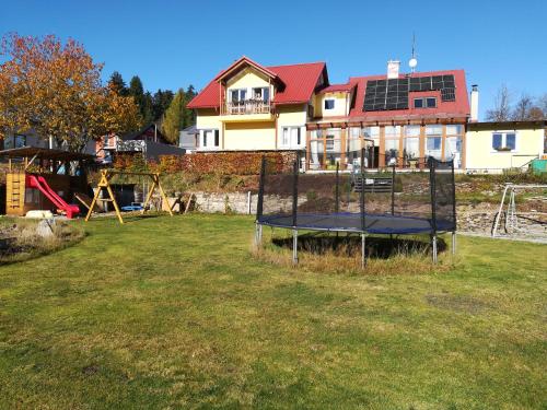 a playground in front of a house with a trampoline at Apartments Pernink 341 in Pernink