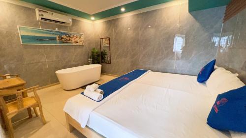 Schlafzimmer mit einem Bett, einer Badewanne und einem Waschbecken in der Unterkunft KISS Hotel Tân Bình in Ho-Chi-Minh-Stadt