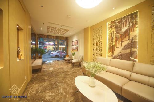 a living room with a couch and a table at L'amant de Hanoi Hotel - khách sạn Lamant de Hà Nội in Hanoi