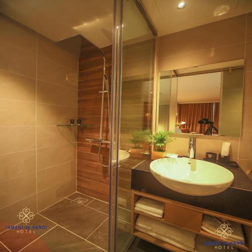 a bathroom with a sink and a shower at L'amant de Hanoi Hotel - khách sạn Lamant de Hà Nội in Hanoi