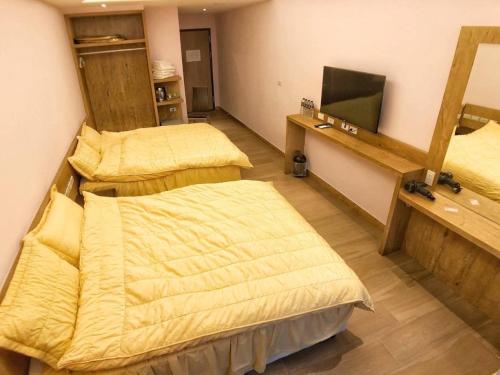 馬公市にあるShun Cheng Hotelのベッド2台と鏡が備わる客室です。