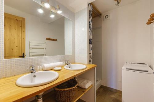 La salle de bains est pourvue de 2 lavabos et d'un miroir. dans l'établissement Petit Chalet Des Moussoux - Happy Rentals, à Chamonix-Mont-Blanc
