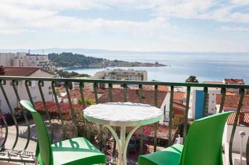 a table with a green umbrella sitting on top of it at Villa Rosa in Makarska