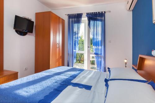 a bedroom with a bed and a tv and a window at Villa Rosa in Makarska