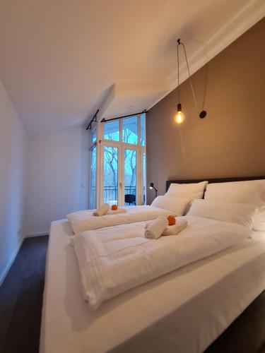 een witte slaapkamer met 2 bedden en een raam bij Penthouse in Villa am Wasser + Parken + WLAN + Netflix +Kamin in Wildau