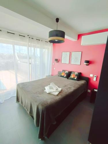 - une chambre avec un grand lit et un mur rose dans l'établissement Cap d'Agde Naturiste F, au Cap d'Agde