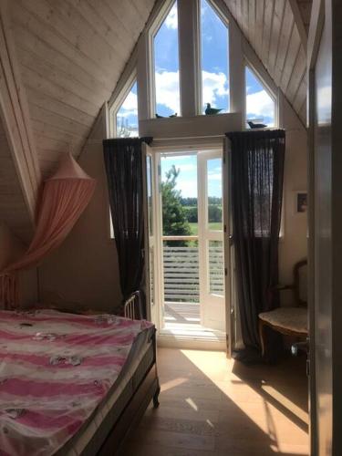a bedroom with a bed and a large window at Villa Verstas Karjalohja in Karjalohja