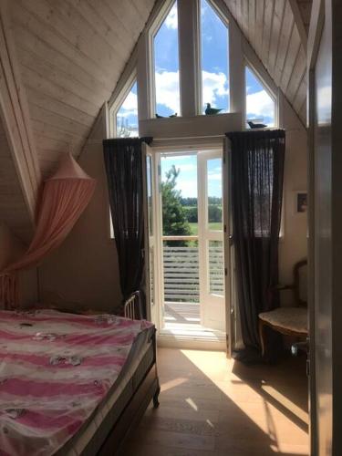 - une chambre avec un lit et une grande fenêtre dans l'établissement Villa Verstas Karjalohja, à Karjalohja
