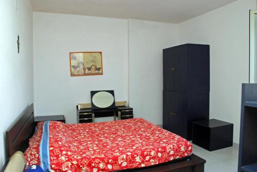 Schlafzimmer mit einem Bett mit einer roten Decke und einem Spiegel in der Unterkunft Bella Otranto in Otranto