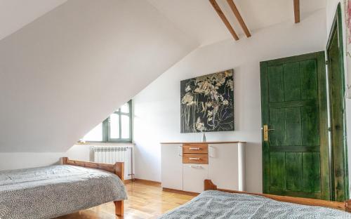 1 dormitorio con 2 camas y puerta verde en Casa Mila Zlatibor en Zlatibor