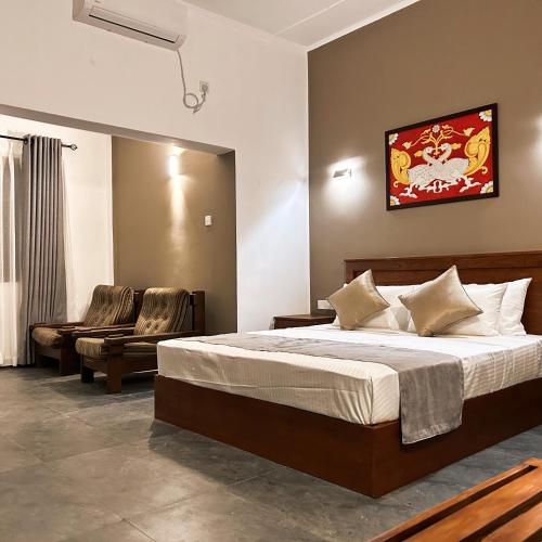1 dormitorio con 1 cama grande y 1 silla en Cliveland Residence, en Kandy