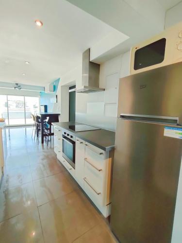 une cuisine avec un réfrigérateur en acier inoxydable et une table dans l'établissement Cap d'Agde Naturiste F, au Cap d'Agde