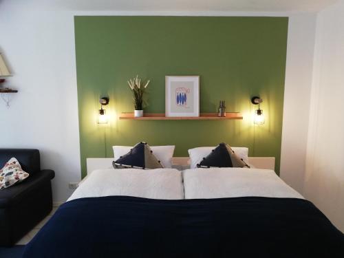 a bedroom with a bed and a green wall at Kajüthus Apartment 5 in Fehmarn