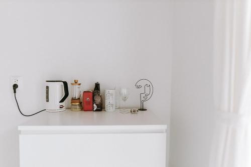 a white counter with bottles and glasses on it at Apartmány Starák v historickém centru Znojma in Znojmo