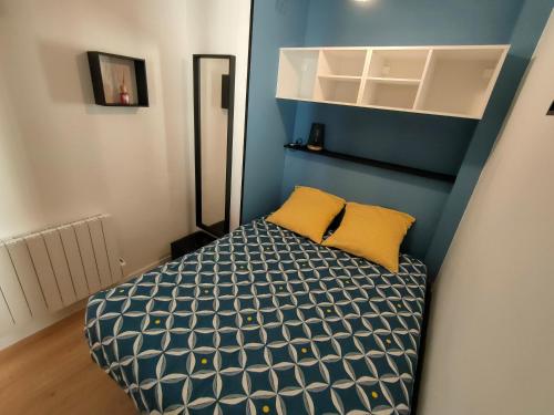 Cette petite chambre comprend un lit avec un mur bleu. dans l'établissement Bel appartement au bord de l'océan, à Saint-Jean-de-Monts