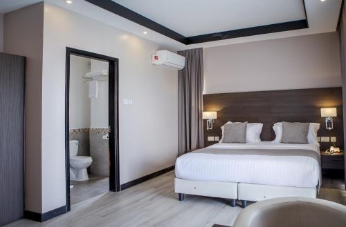 Ένα ή περισσότερα κρεβάτια σε δωμάτιο στο Source of The Nile Hotel- Namanve Branch