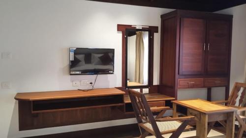 Zimmer mit einem Schreibtisch und einem TV an der Wand in der Unterkunft Cherai Beach View Heritage in Cherai Beach