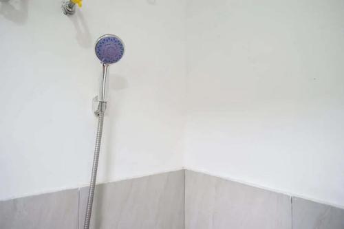 a shower head on the side of a wall at RedDoorz Syariah near Universitas Jenderal Soedirman 2 in Purwokerto