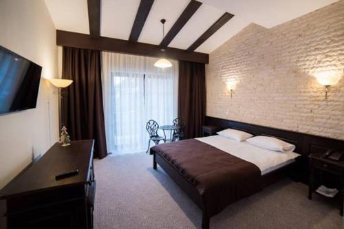 Piatra Pinului Ski & Spa في جورا هومورولوي: غرفة فندقية بسرير وتلفزيون بشاشة مسطحة