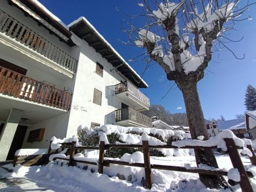 a tree covered in snow next to a building at La Maison Everest 73 - bilocale a La Ruine, Morgex in Morgex