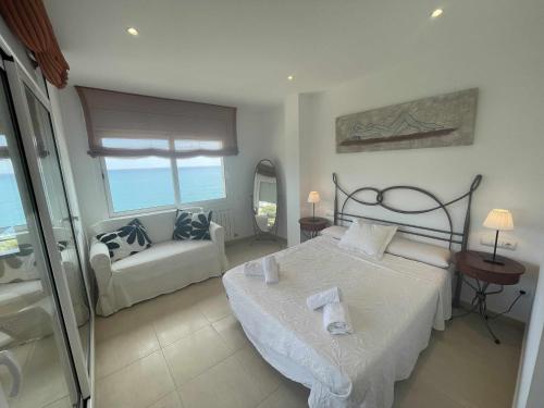 a bedroom with a bed and a couch in it at Villa Farell just in front of the sea in San Pol de Mar