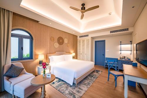 a hotel room with a bed and a couch at Centara Mirage Resort Mui Ne in Mui Ne