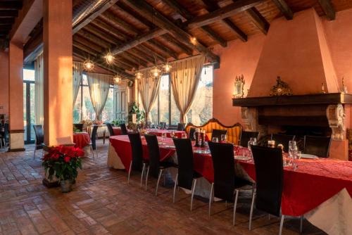 ein Esszimmer mit roten Tischen und Stühlen und einem Kamin in der Unterkunft La Chiesuola in Viterbo