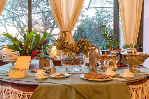 einem Tisch mit Teller mit Lebensmitteln vor einem Fenster in der Unterkunft La Chiesuola in Viterbo