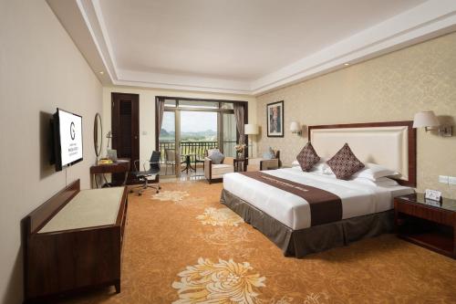 a hotel room with a bed and a living room at Maoming Country Garden Phoenix Hotel in Dianbai