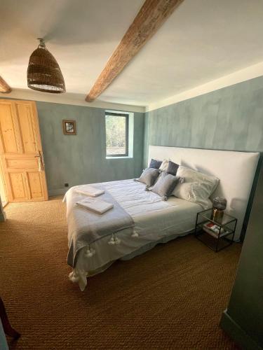 um quarto com uma cama grande e paredes azuis em Cévennes - Magnifique chambre d'hôtes, indépendante et moderne em Monoblet