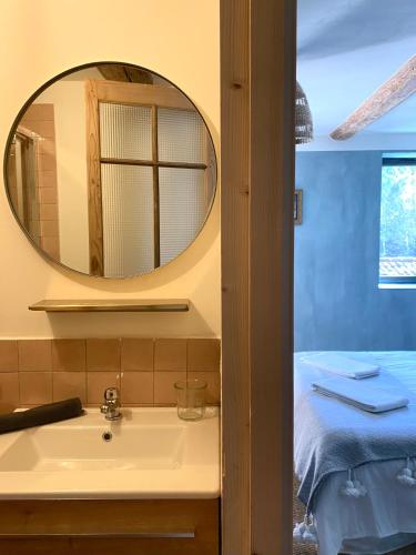La salle de bains est pourvue d'un lavabo et d'un miroir. dans l'établissement Cévennes - Magnifique chambre d'hôtes, indépendante et moderne, à Monoblet