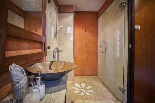 a bathroom with a bowl sink and a shower at MamaLek Boutique Pattaya Poolvill 20m to Beach in Na Jomtien